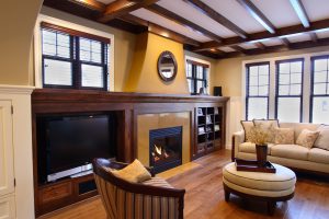 Living room with cabinets on either side of fireplace and wooden beams on ceiling
