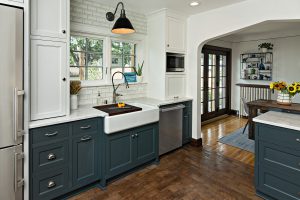 Kitchen with painted cabinets and an apron front sink with window above