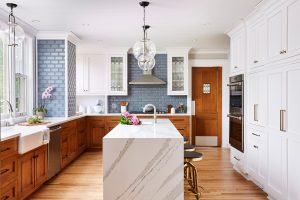 Kitchen with quartersawn red oak base cabinets, painted uppers and quartz island with waterfall edge