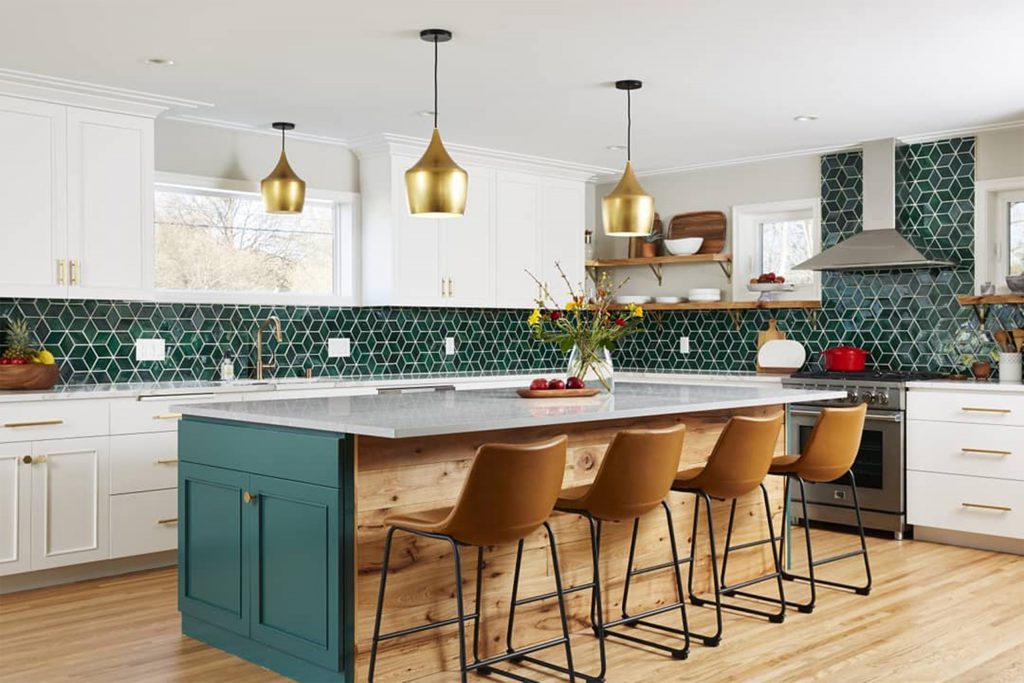 Kitchen with painted white perimeter cabinets and a painted green island that ties in with green tiled back splash