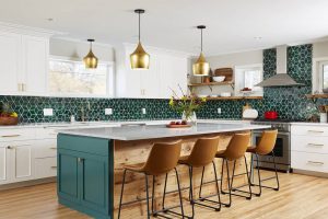 Kitchen with painted white perimeter cabinets and a painted green island that ties in with green tiled back splash