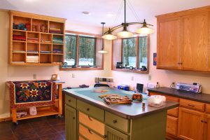 Sewing room with oak cabinets and a painted island