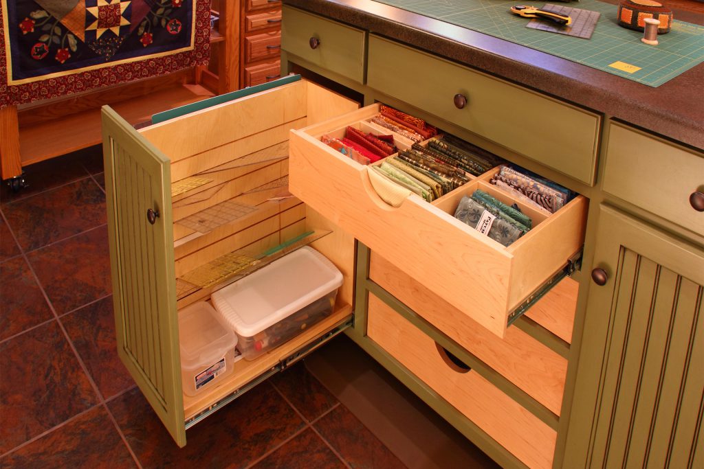 Sewing room cabinet with pull-out drawer for fabric and tool organization
