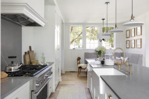 Side view of kitchen with painted cabinets and an apron front sink in the island